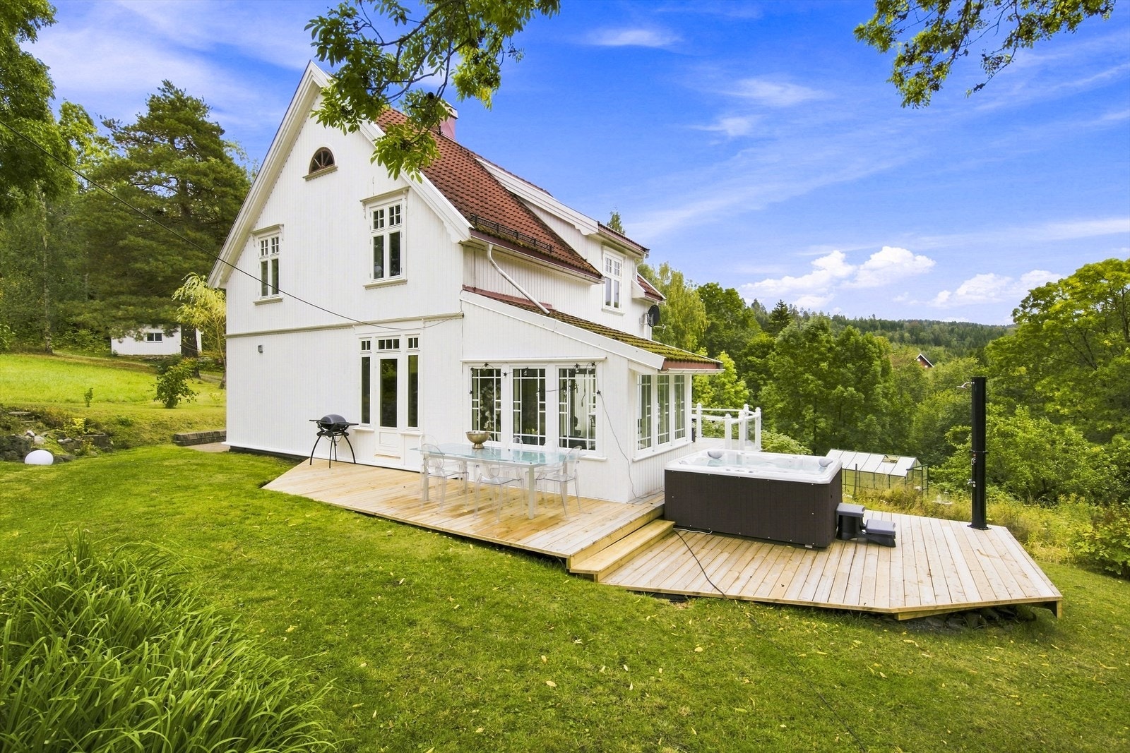 Utenfor hovedboligen strekker terrassen seg med plass til både spisegruppe og jacuzzi. Galleribilde