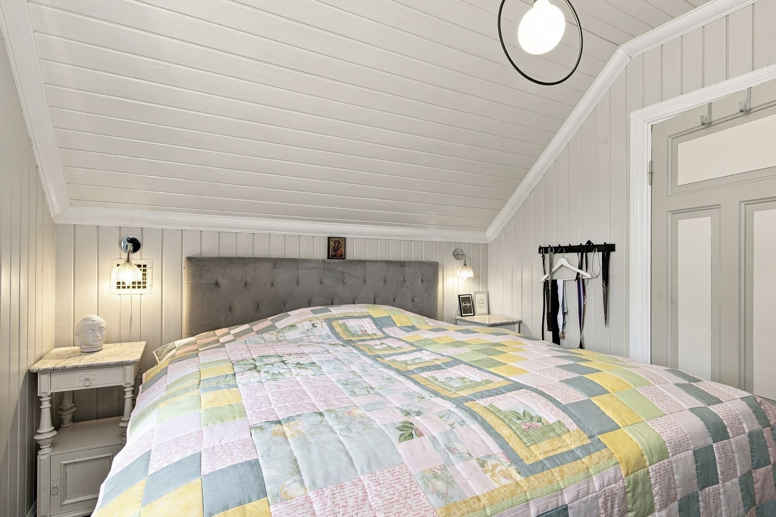 Soverom innredet med plass til dobbeltseng og nattbord under skråtaket. Galleribilde