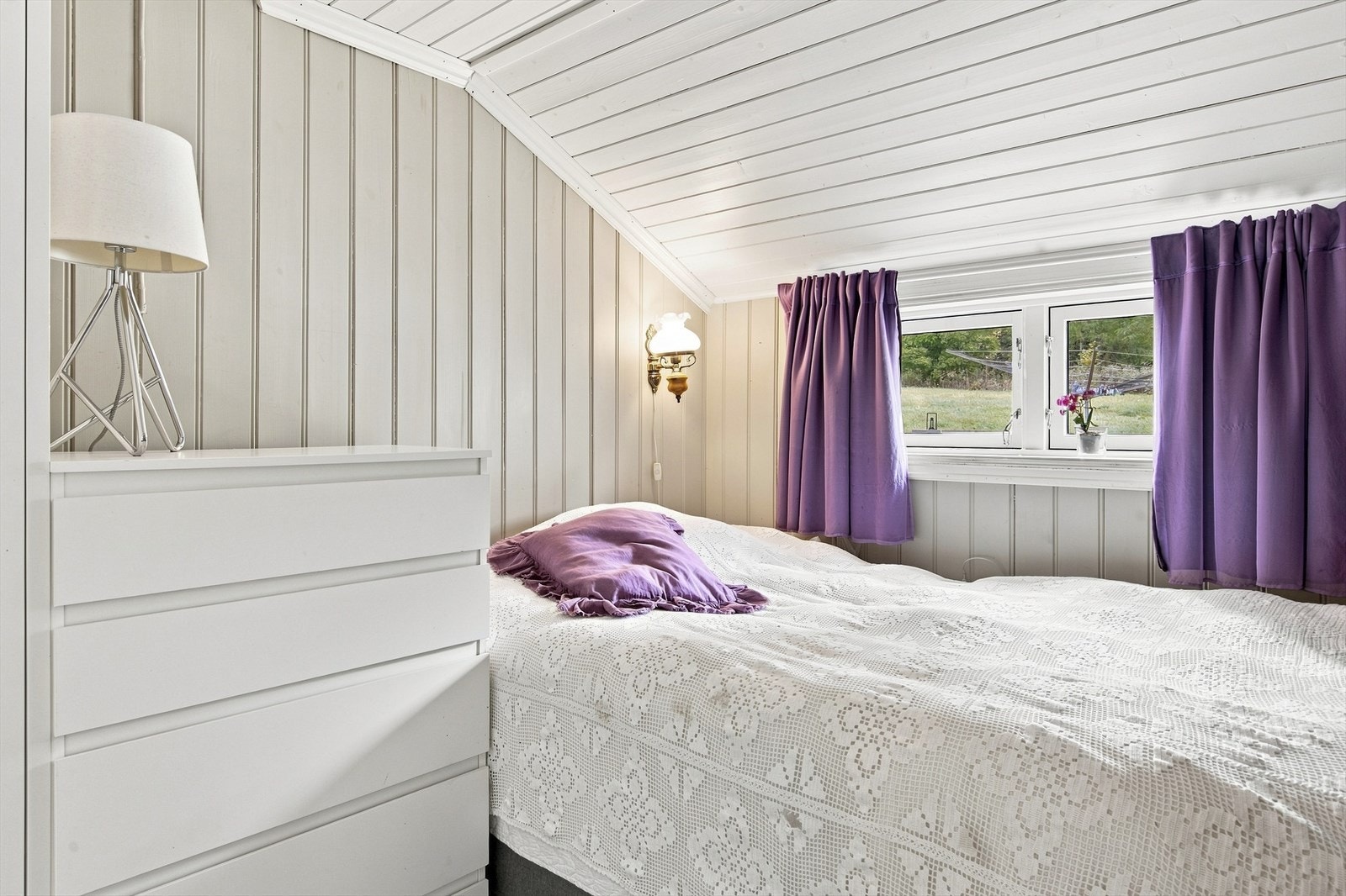 Innredet soveplass etablert i allrommet med panelte flater og vindu mot tomten. Galleribilde