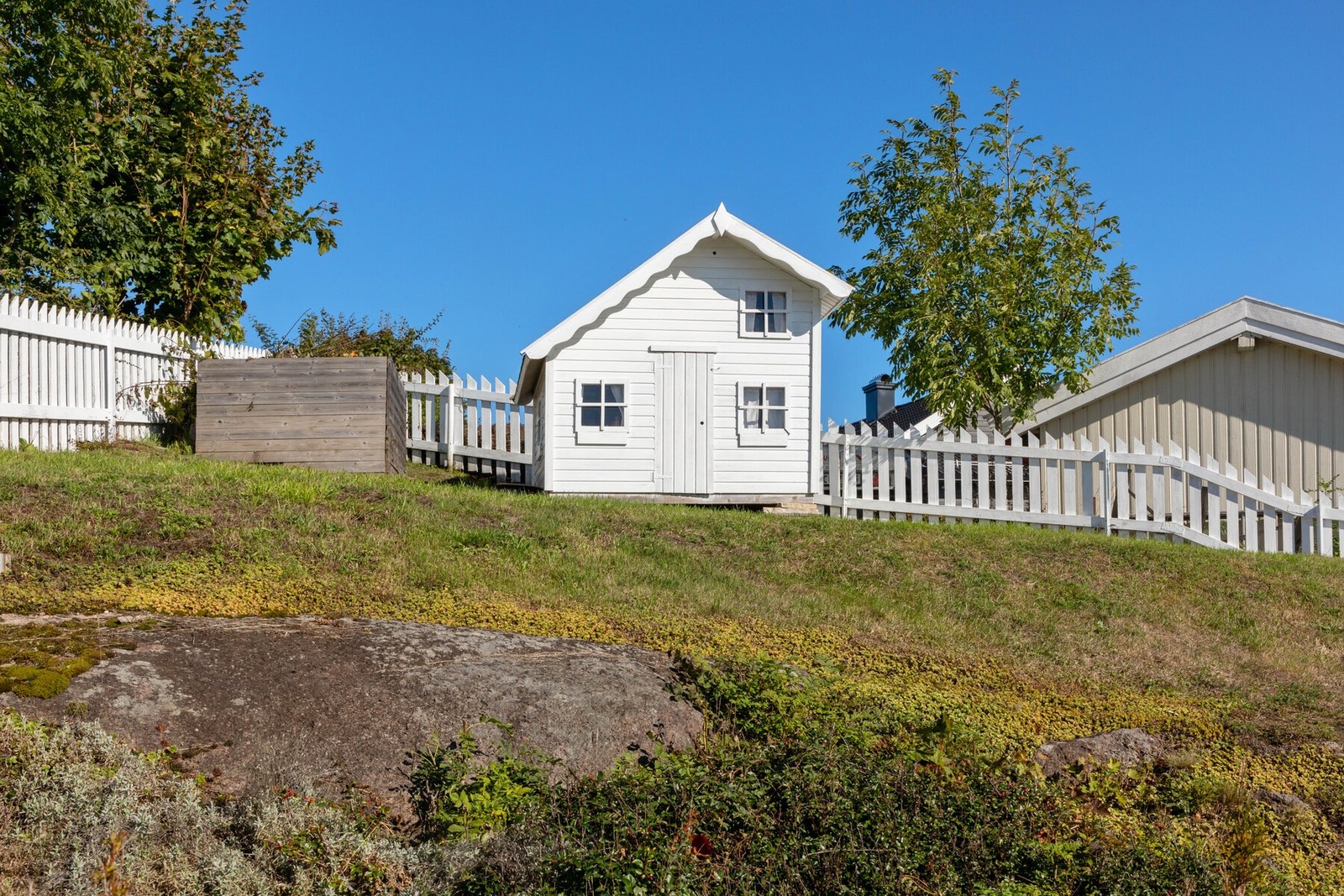 Pent opparbeidet uteområde med en fin kombinasjon av naturlig fjell og velstelt gressplen. Galleribilde