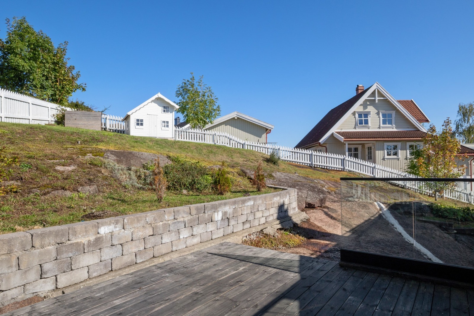 Mellom nivåene i hagen er det trapper og støttemurer, og hele tomten rammes inn med hvitmalt gjerde. Galleribilde
