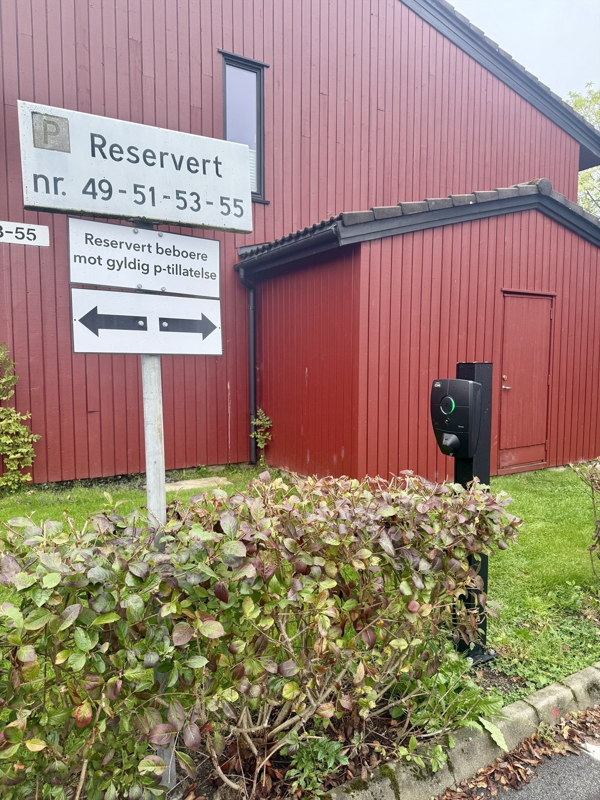 Rett utenfor er det reserverte parkeringsplasser med felles elbil-lader Galleribilde