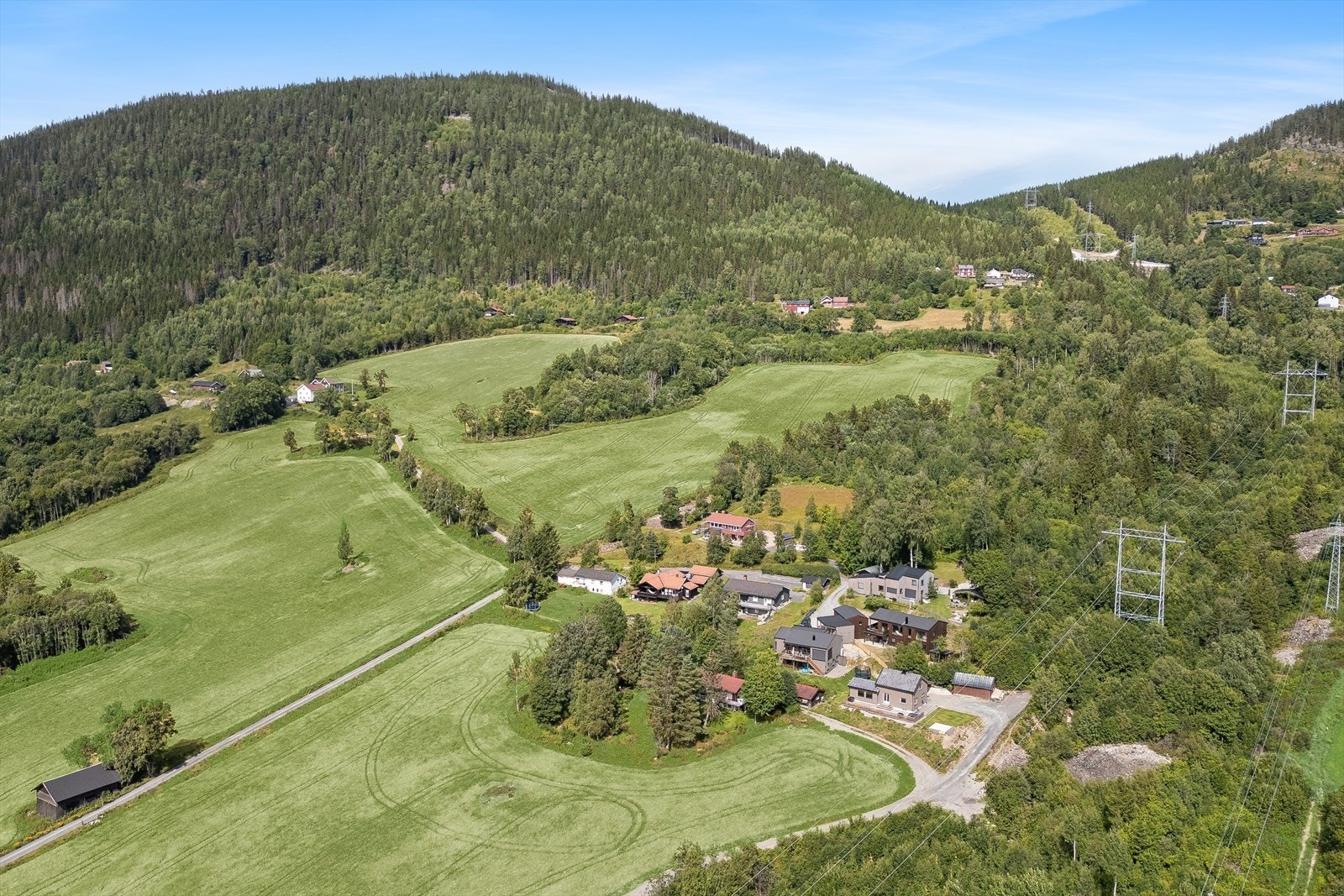 Beliggenhet i et område preget av eneboliger og landbruk. Galleribilde