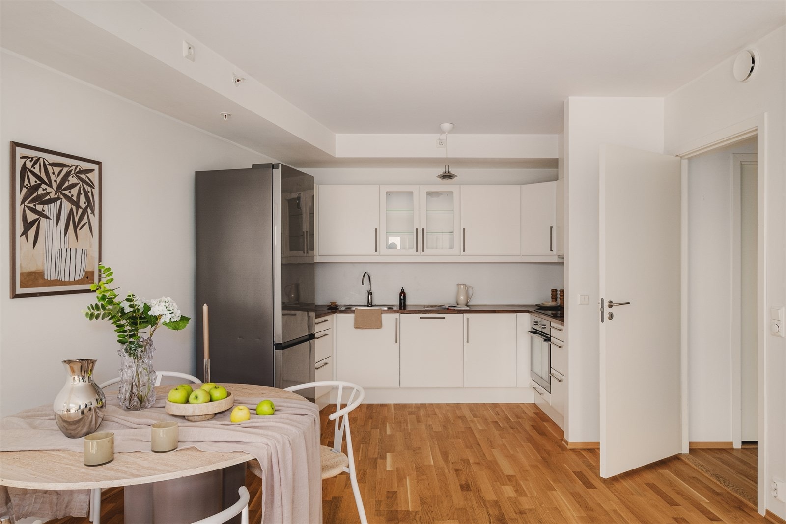- Designa kjøkkeninnredning med slette hvite fronter, overskap med glassfronter, benkeplate i laminat, underlimt stål vaskekum og ventilator - Galleribilde