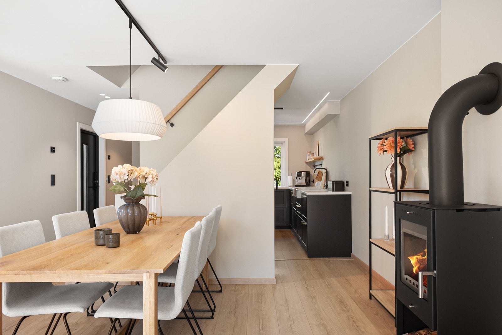 Stuen er et lyst og hyggelig oppholdsrom med en naturlig inndeling mellom spiseplass og sofagruppe. Vedovnen tilfører både varme og stemning. Galleribilde