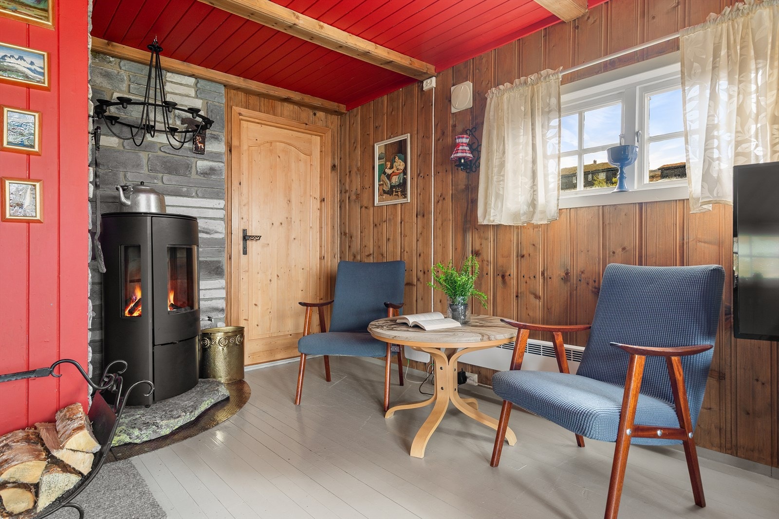 Vedomnen i stova bidreg med både varme og ekte hyttestemning. Hytta har elles elektriske panelomnar som oppvarming. Galleribilde