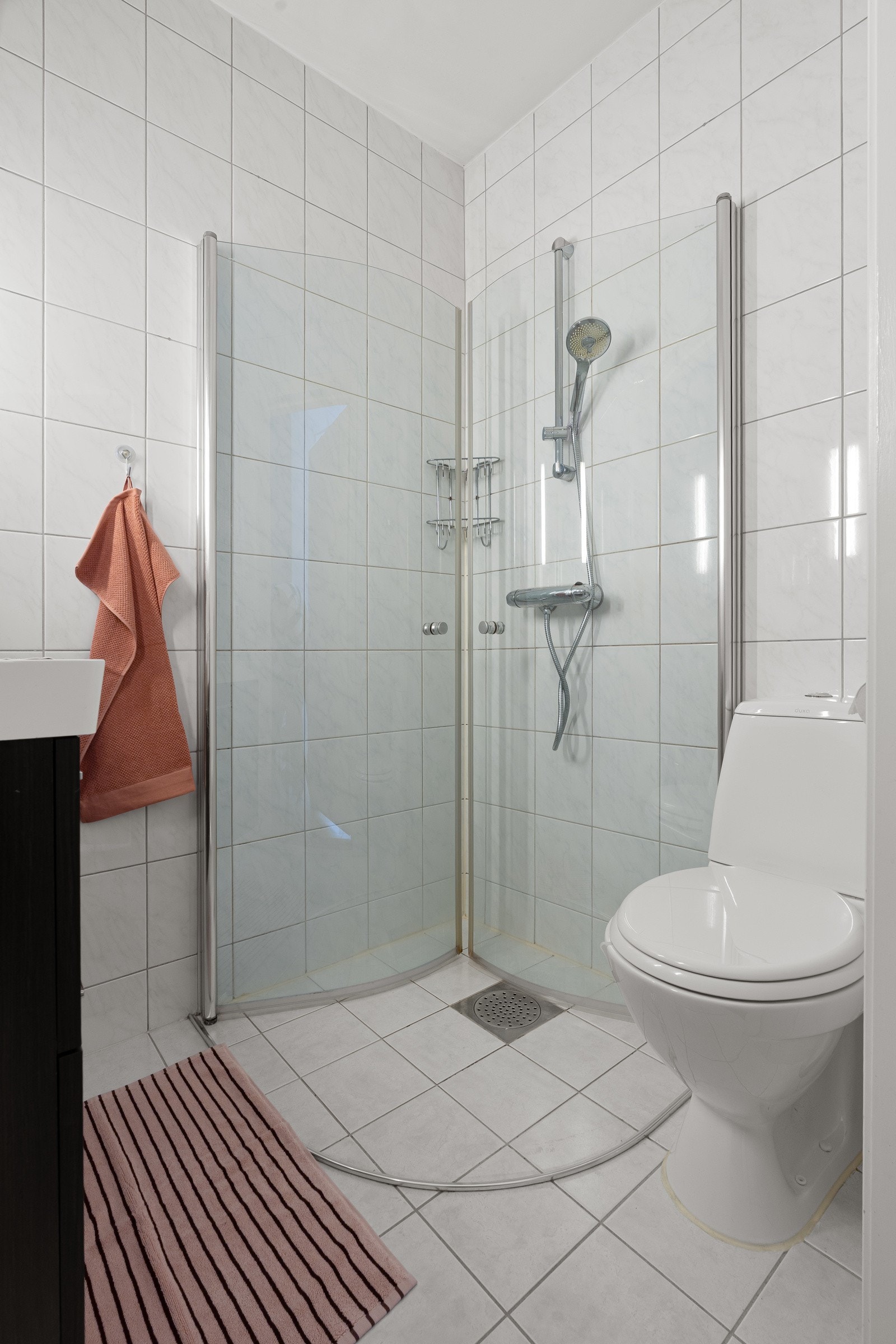 Flislagt bad med dusjhjørne og wc.