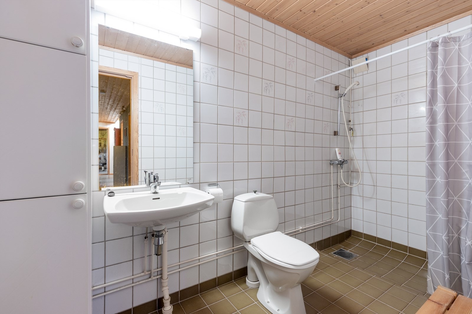 Bad i sokkeletasjen med keramiske fliser, gulvvarme, toalett og dusjhjørne. Galleribilde
