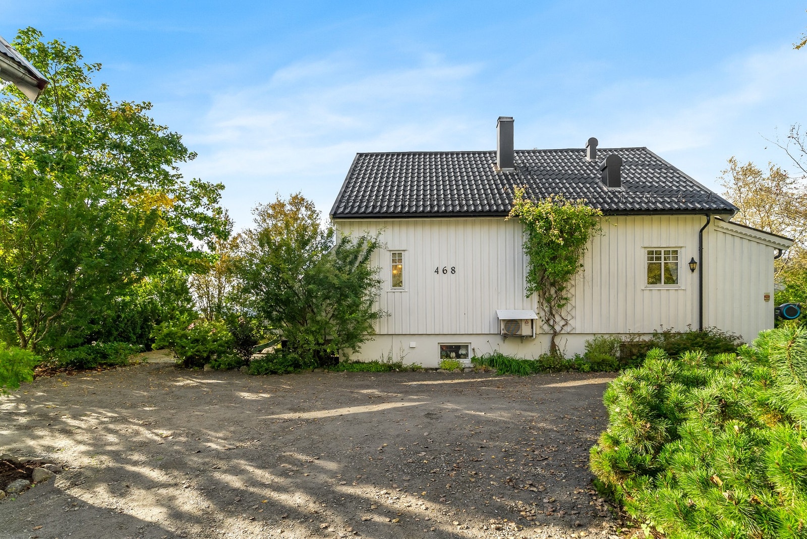 Fasade på Tverlandsveien 468 med hvitmalt stående kledning. Galleribilde