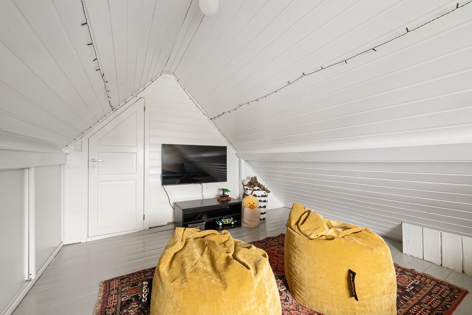 Loftsrommet har hvitmalt trepanel på vegger og tak. Galleribilde