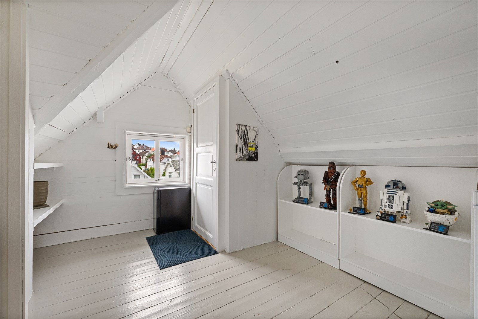 Malt furugulv og plassbygde hyller under skråtaket. Galleribilde