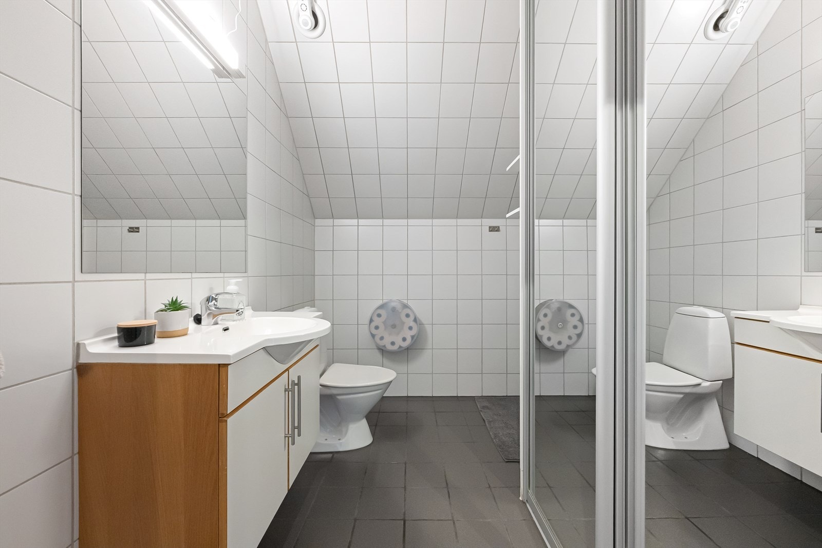 Badet har flislagt gulv med gulvvarme, fliser på veggene og dusjhjørne. Galleribilde