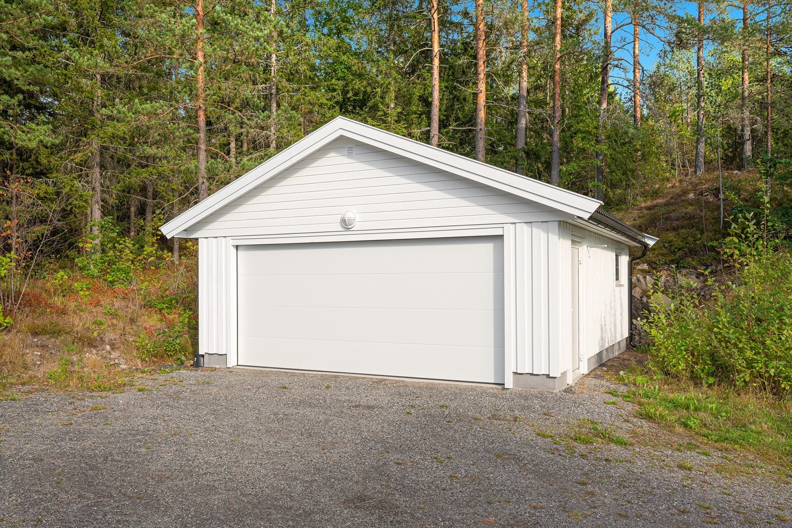 Dobbel garasje fra 2021 med automatisk portåpner. Det er ellers god plass til parkering på tomten. Galleribilde