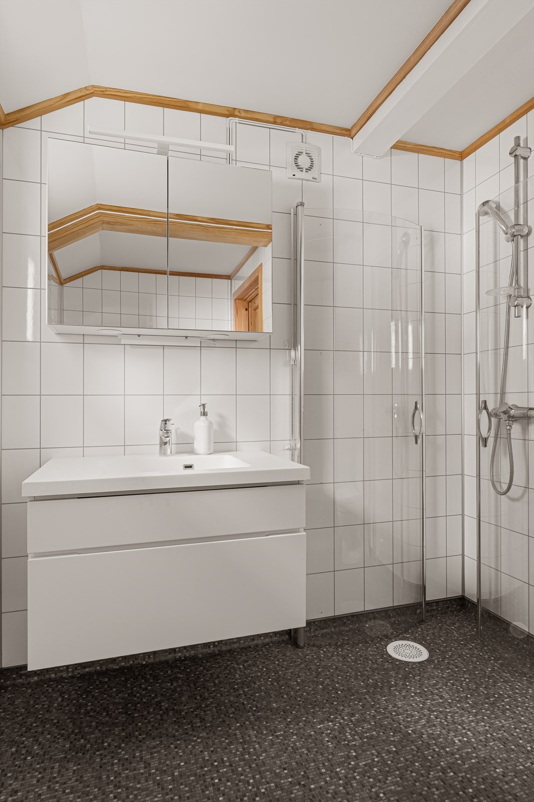 Badet har belegg med varmekabler på gulv og inneholder dusjkabinett, servant, toalett og dusjkabinett. Galleribilde