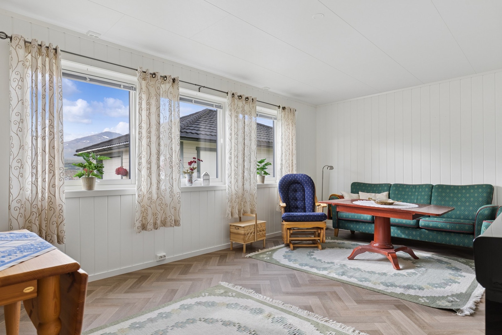 Rommet har panelte vegger og vinduer som vender ut mot omgivelsene. Galleribilde