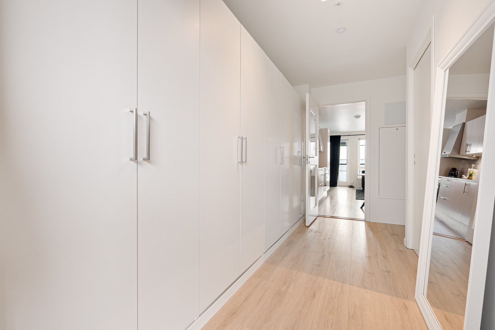 Man ønskes velkommen inn i en lys og romslig gang utstyrt med rikelig med garderobeskap som gir rikelig med lagringsplass. Galleribilde