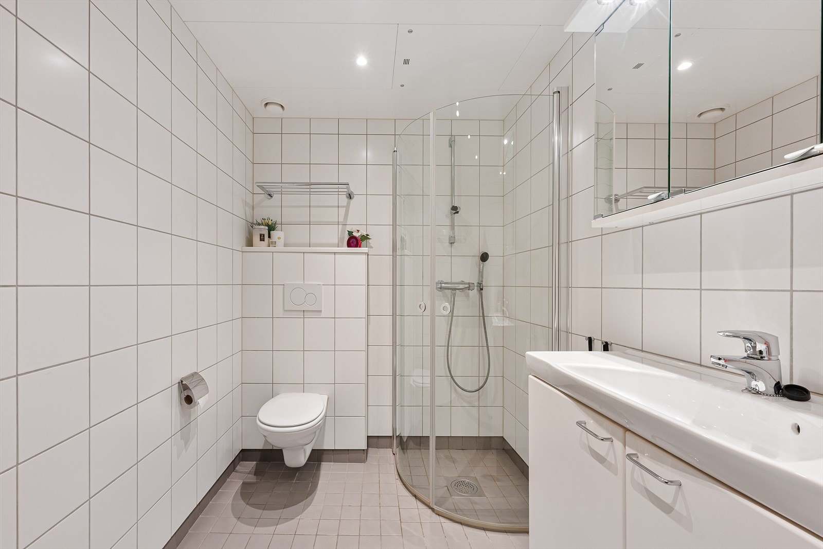 Badet er ellers utstyrt med dusjhjørne, vegghengt toalett og baderomsinnredning med nedfelt servant. I tillegg har man opplegg for vaskemaskin. Galleribilde