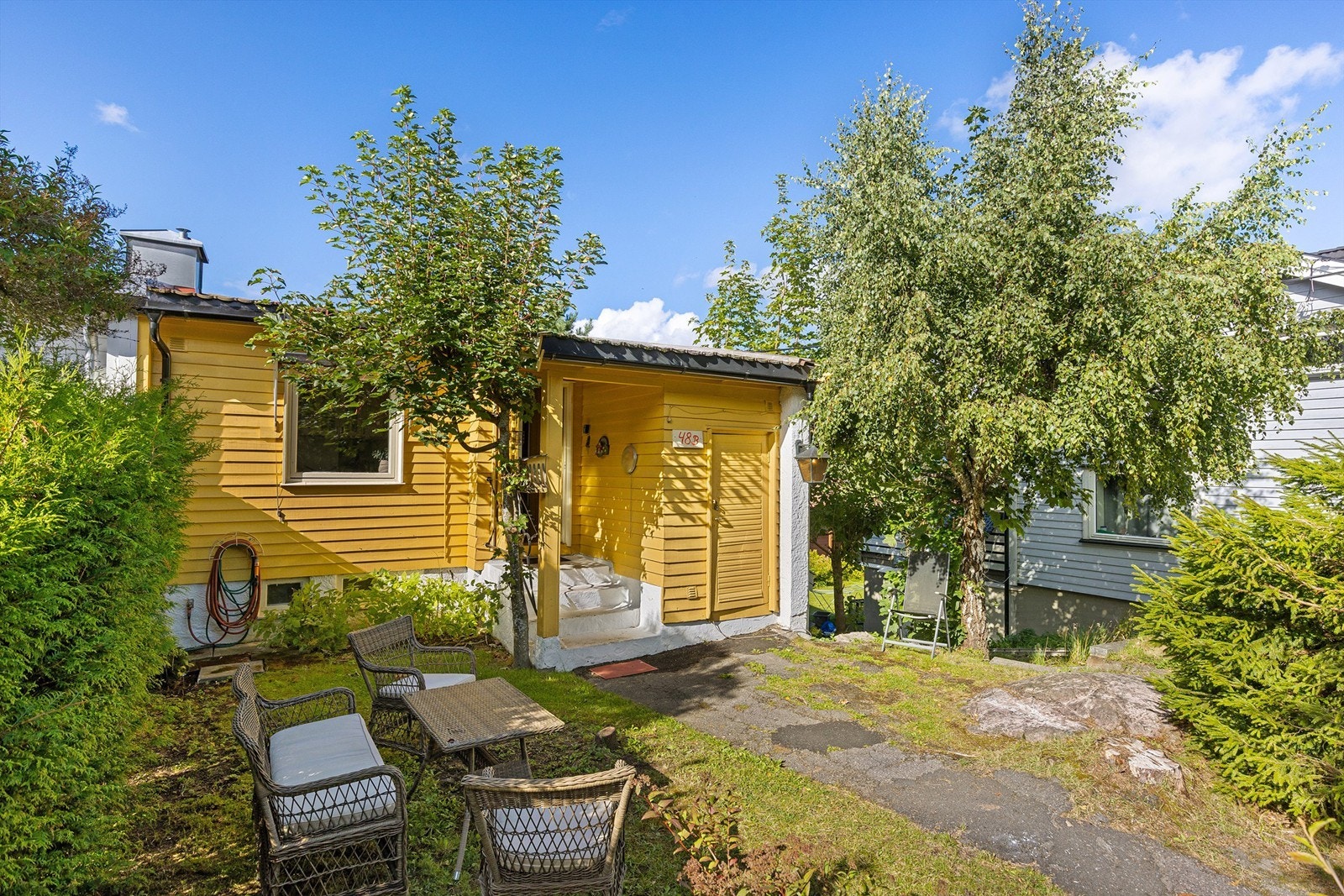 Hyggelig inngangsparti med grønne omgivelser og plass til utemøbler Galleribilde