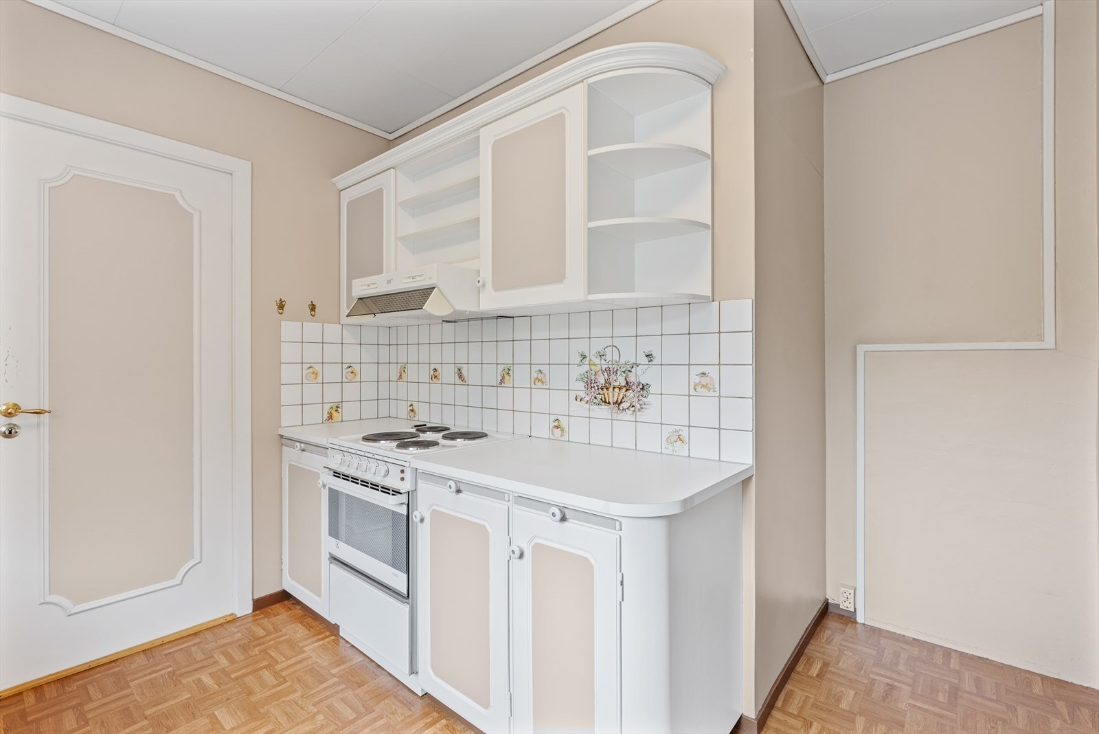 Kjøkkeninnredningen har fliser over benken og ventilator over komfyrplassen. Galleribilde