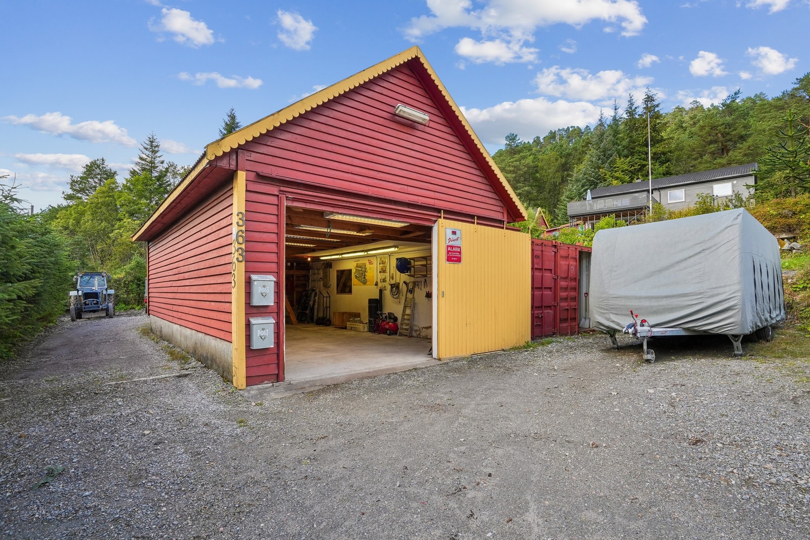 Garasjen suppleres av romslig gruset gårdsplass med gode parkeringsmuligheter. Galleribilde