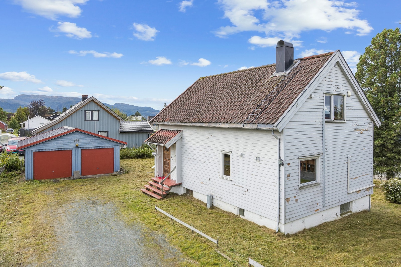 Boligen har frittliggende dobbelgarasje og god plass fremfor huset. Fasaden bærer preg av mange år med manglende vedlikehold. Galleribilde