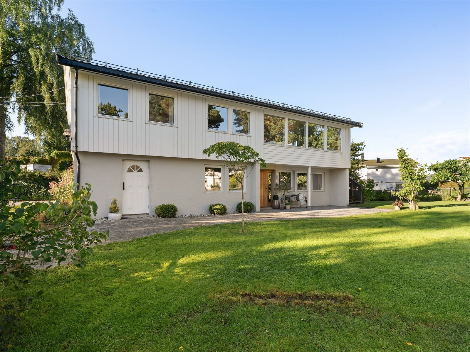 Boligen har en flat tomt med stor hage og solrike uteområder. Galleribilde