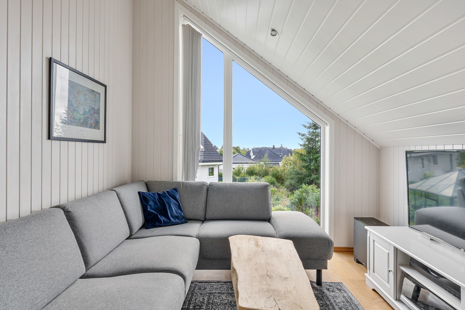 Loftstuen har god plass til sofagruppe under det moderne vinduspartiet. Galleribilde
