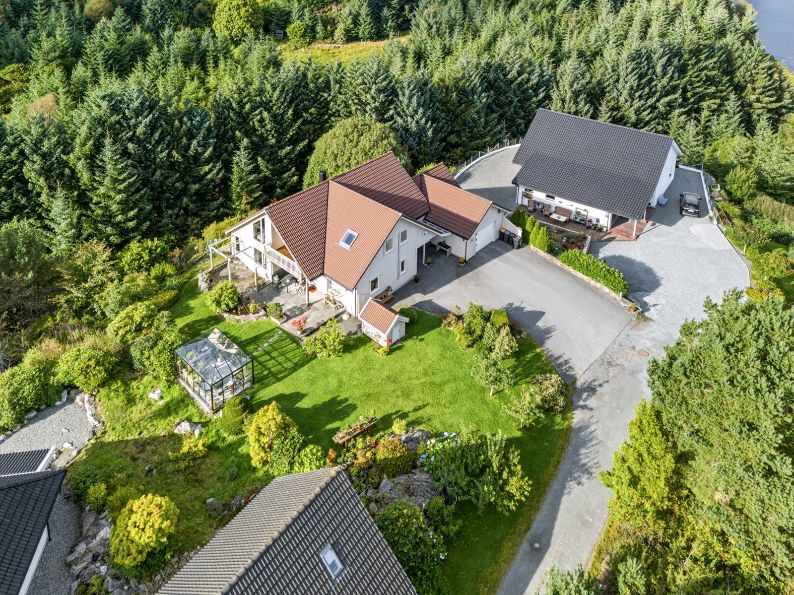 Eiendommen har en stor, usjenert tomt omgitt av skog og grøntområder. Galleribilde