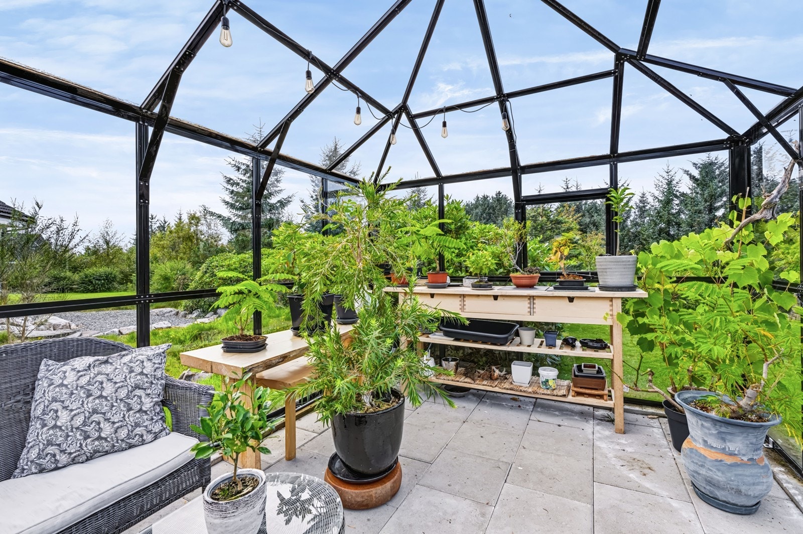 Drivhuset er innredet med arbeidsbenker for dyrking av planter og vekster. Galleribilde