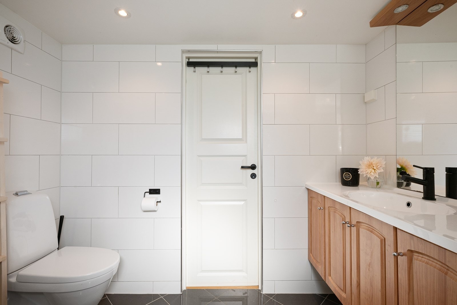 Badet i første etasje har flislagte overflater, gulvvarme og downlights i himlingen. Galleribilde