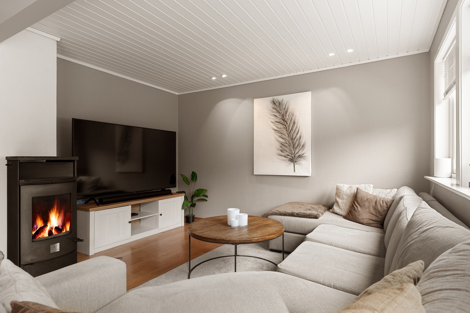 Lun sofakrok ved peisovnen med innfelte downlights i himlingen. Galleribilde
