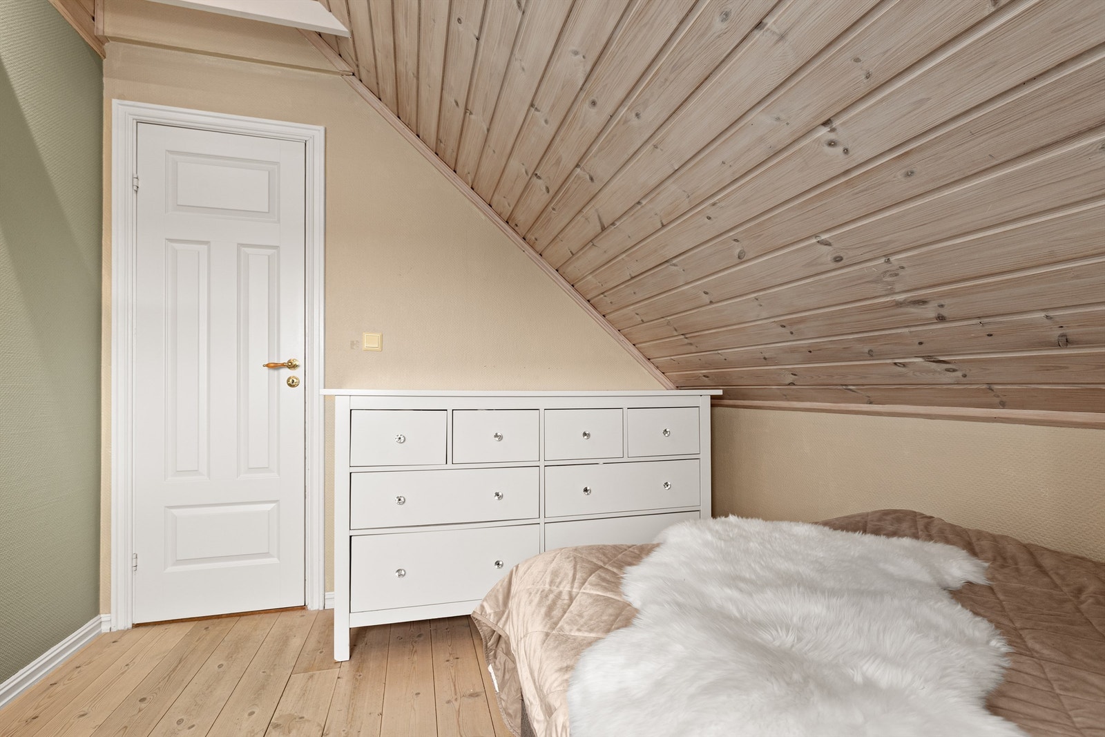 Malt panel på veggene og god plass til kommoder under skråtaket. Galleribilde