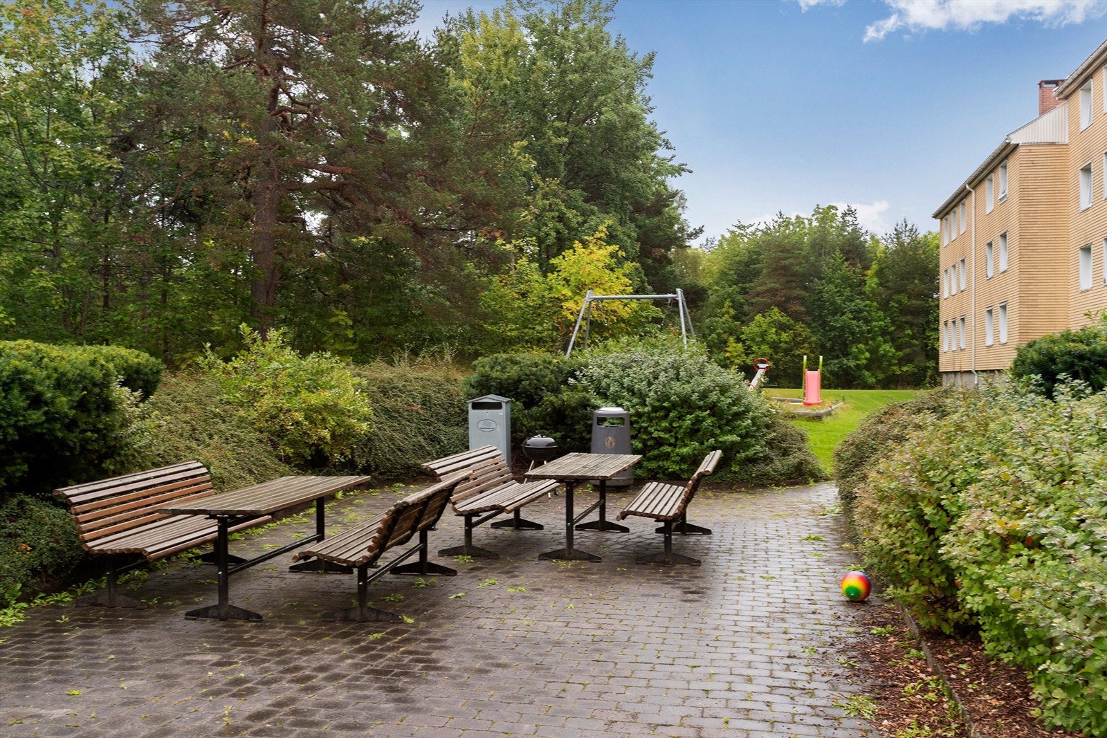 Felles sitteplass med bord og benker til bruk for borettslagets beboere. Galleribilde