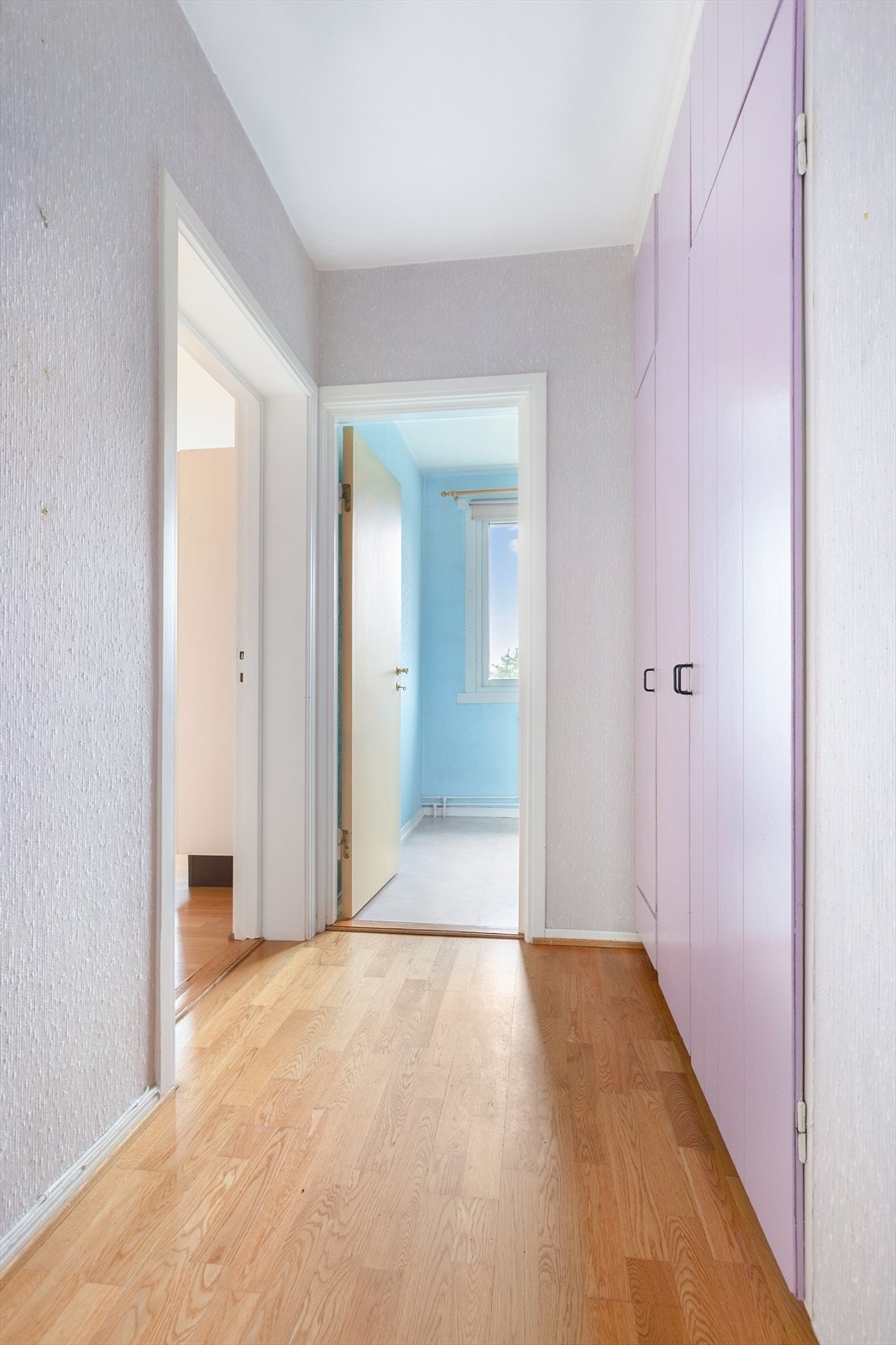 Man kommer inn i en entré med parkett på gulv og tapetserte vegger. Galleribilde