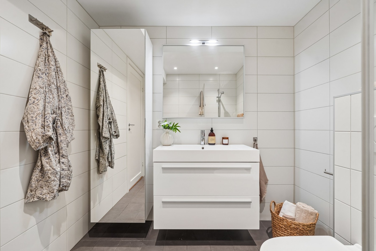 Badet er innredet med en servantinnredning med to skuffer, kompositt servant og speil med belysning over. Speilskapet fra 2019 sørger for ekstra oppbevaringsplass. Galleribilde
