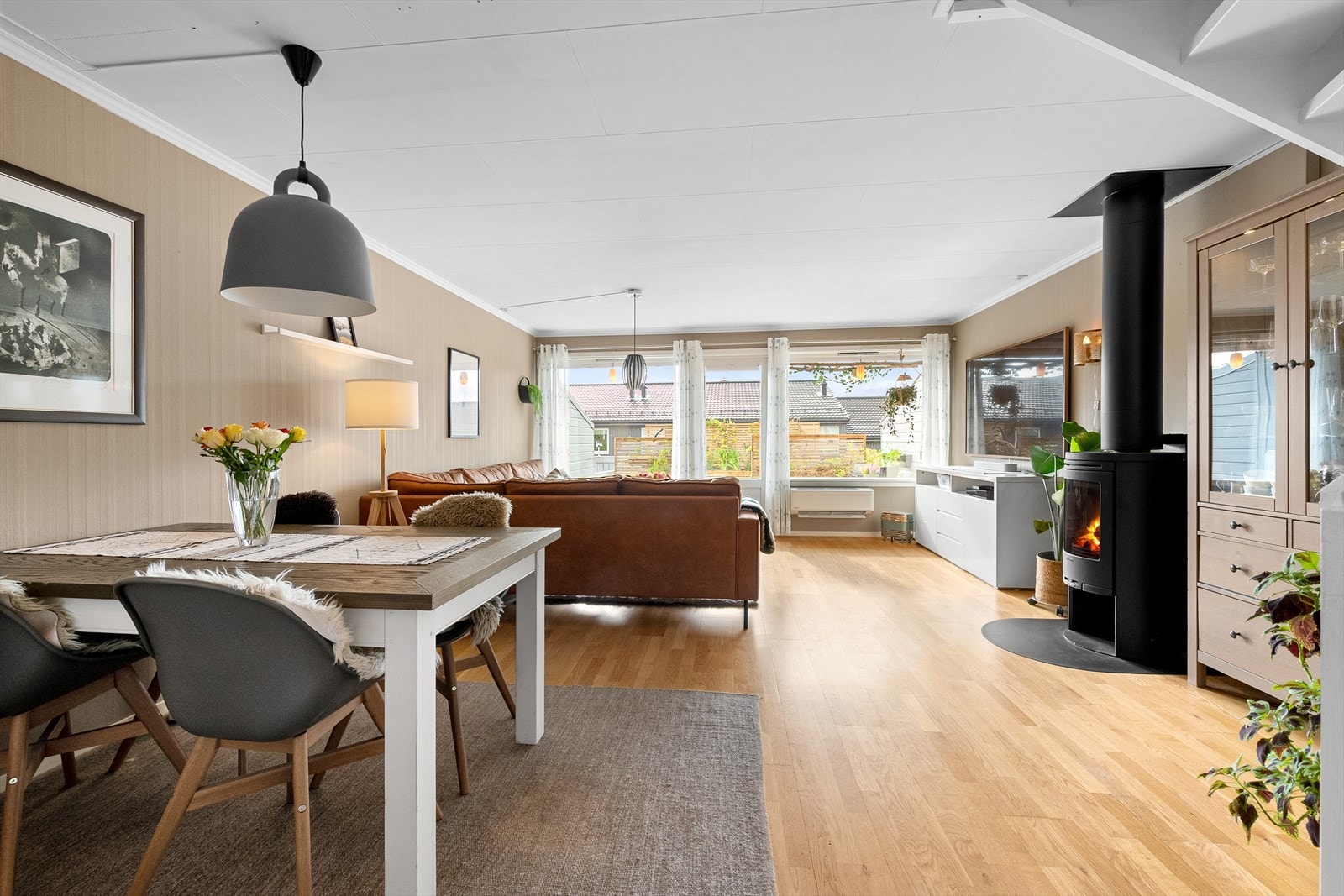 Romslig stue med god plass til både sofagruppe og spisebord. Her er både varmepumpe og ildsted. Galleribilde