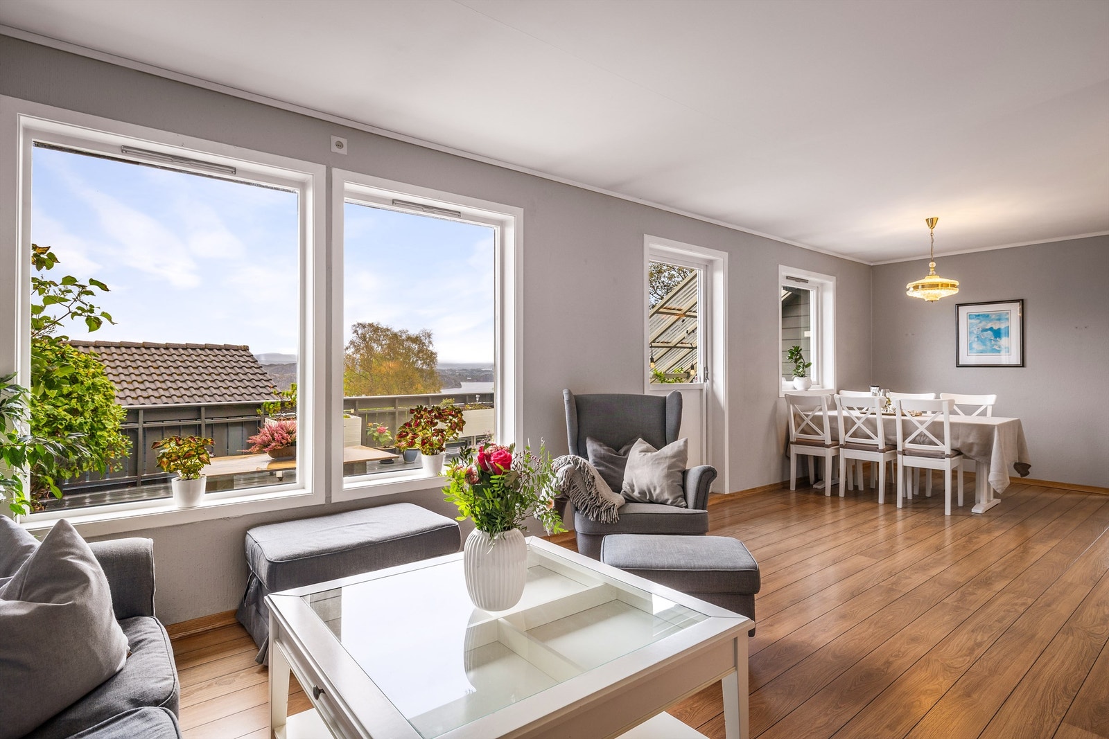 Stue med store vindusflater, fjordutsikt og god plass til både sofagruppe og spisebord. Galleribilde