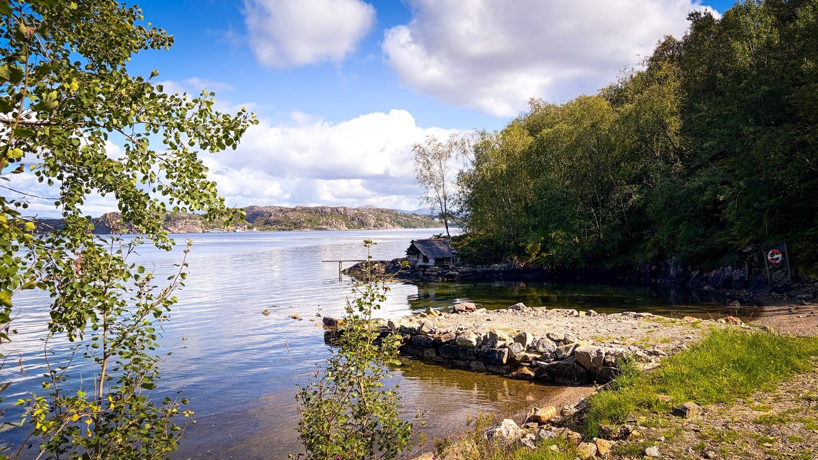 Badeplassen i Grotvika med langgrunn strand og naustmiljø. Galleribilde