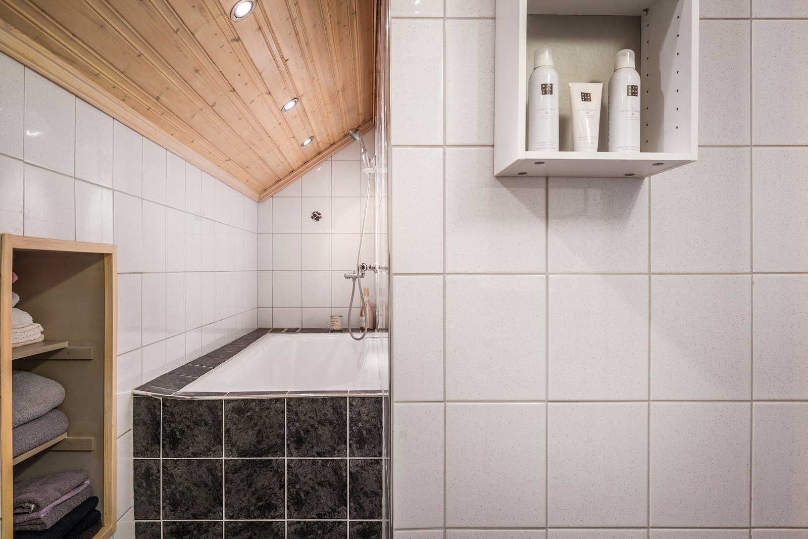 Innbygget badekar og praktisk innfelt hylle i baderomsveggen. Galleribilde