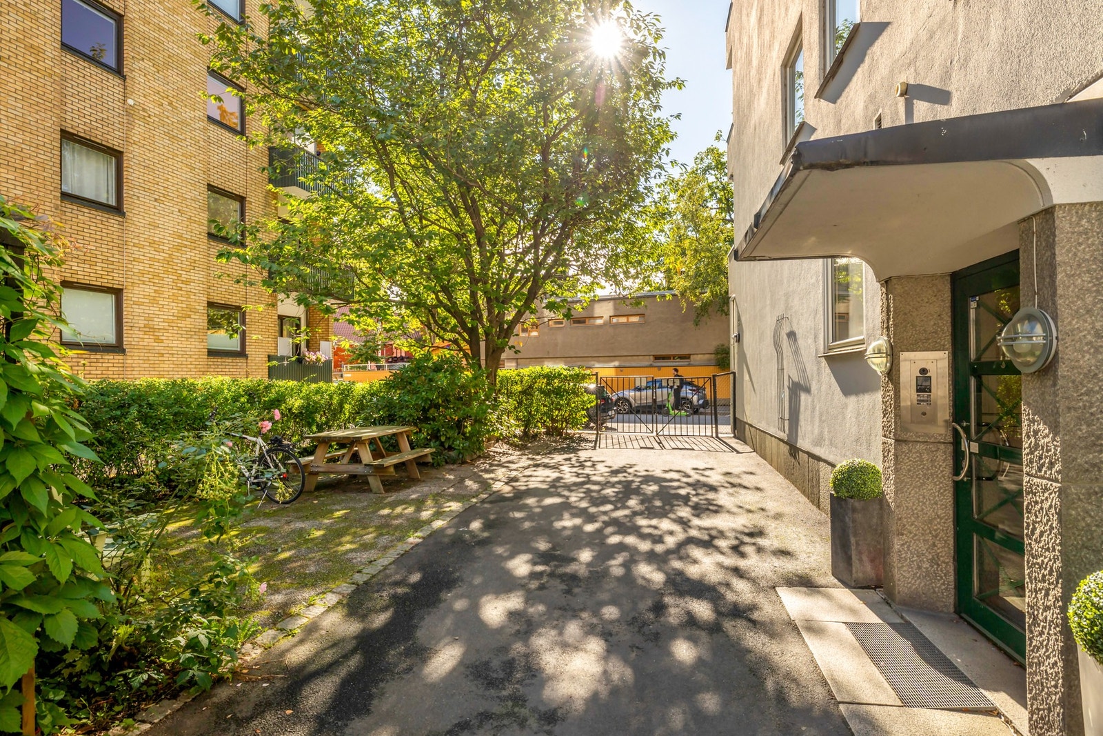 Hyggelig og pent opparbeidet inngangsparti med grønne omgivelser og sittegruppe for beboerne. Galleribilde