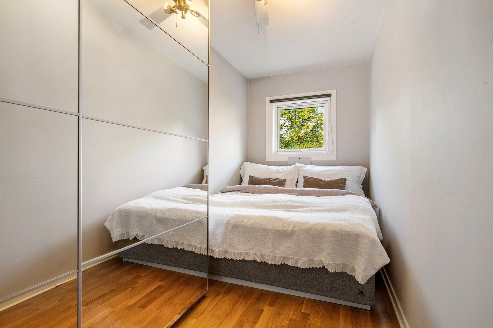 Soverommet er lyst og innbydende med plass til dobbeltseng. Langs den ene veggen er det en stor skyvedørsgarderobe med speilfronter. Galleribilde