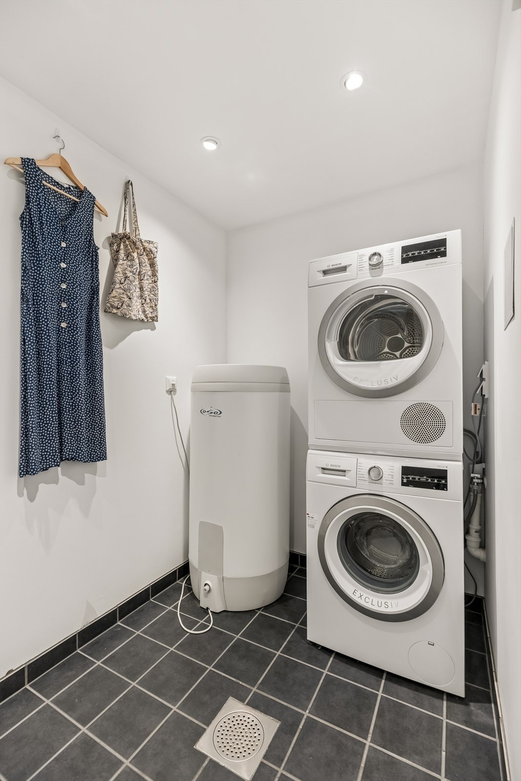 Vaskerom i kjelleretasjen med flislagt gulv med varmekabler og malte slette flater med downlights i himling, samt opplegg for vaskemaskin og tørketrommel. Galleribilde