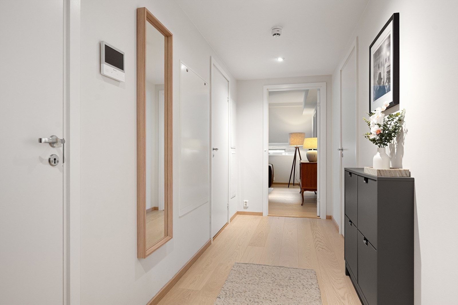Leiligheten ligger i bakkeplan og har i tillegg heisadkomst fra garasjekjelleren. Entréenhar parkett på gulv, lysmalte veggflater og nedsenket himling med downlights. En stilren kombinasjon som er gjennomgående for hele leiligheten. Galleribilde