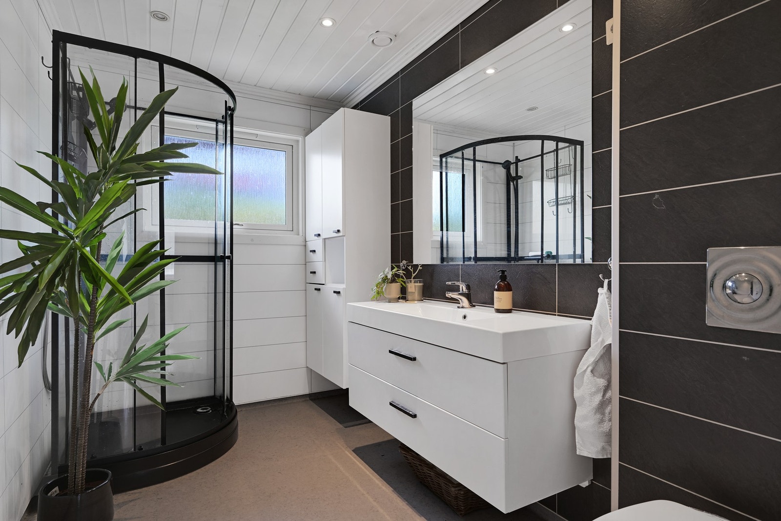 Badet i 1 etasje med baderomsplater på veggene og varmekabler i gulv Galleribilde