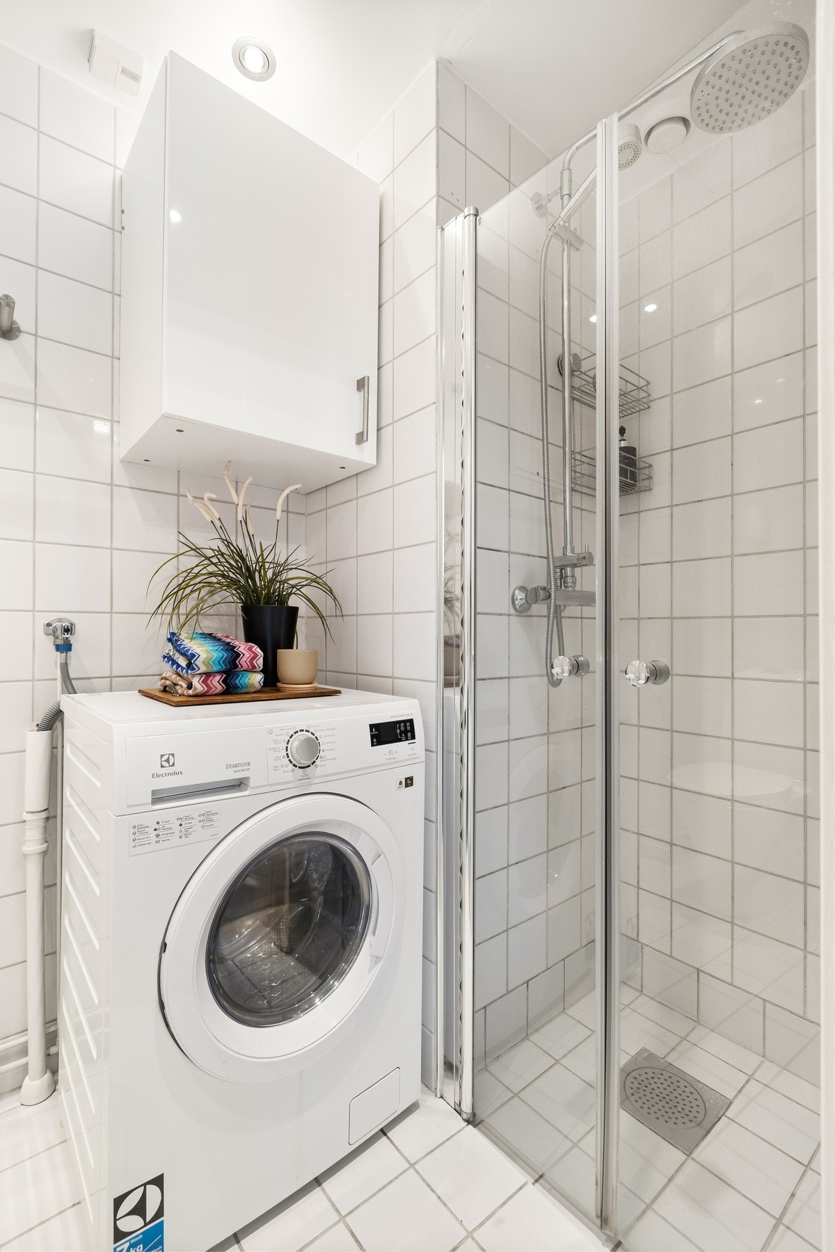 Badet har en praktisk dusjnisje og opplegg for vaskemaskin, som gir en funksjonell og god utnyttelse av rommet. Galleribilde