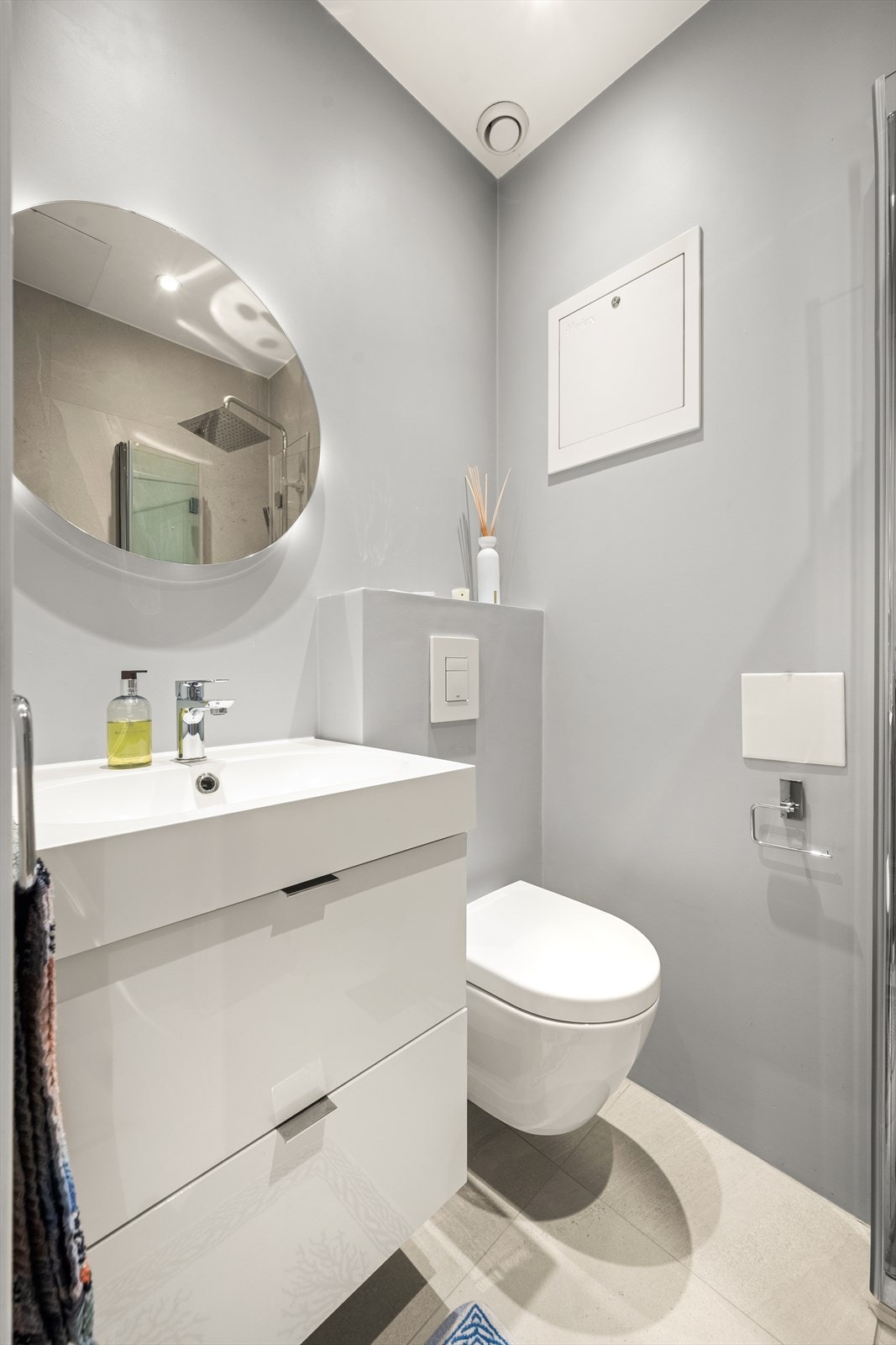 Badet har flislagt gulv med varmekabler, downlights i himling, samt fliser i dusjsone og på én vegg. Øvrige vegger er malt i en moderne og behagelig fargepalett. Galleribilde