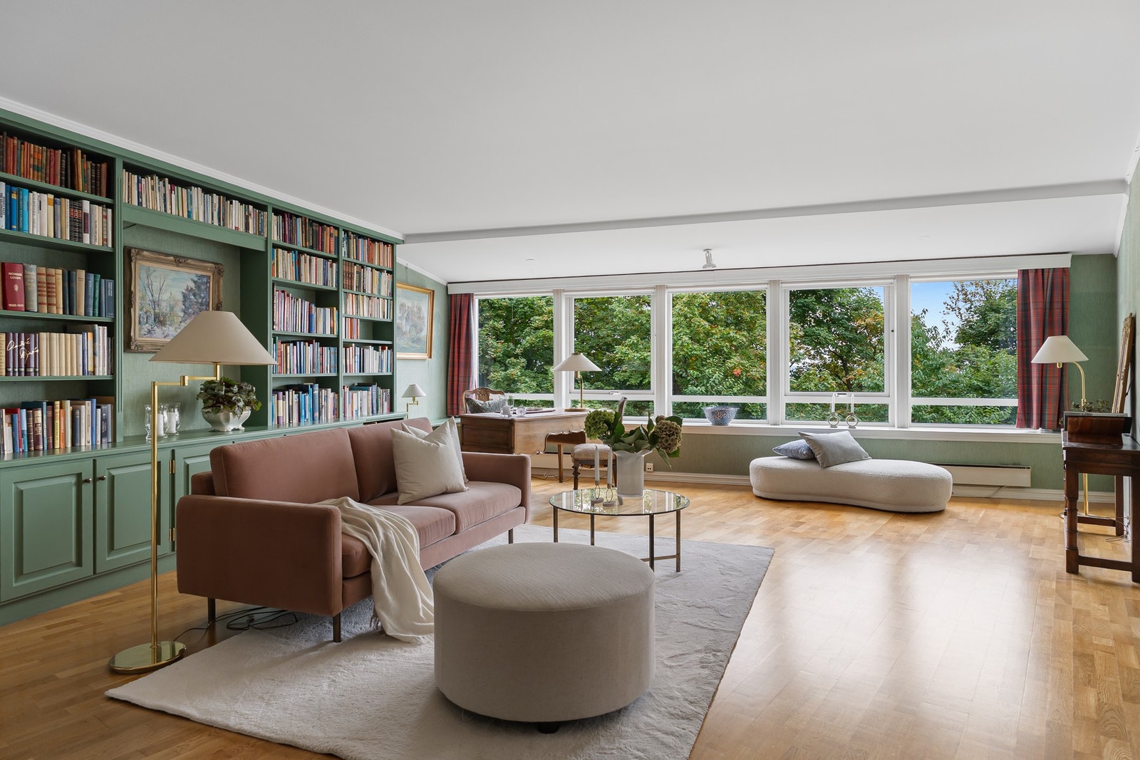 Romslig og stemningsfull peisestue med plassbygd bokhylle og store vindusflater. Galleribilde