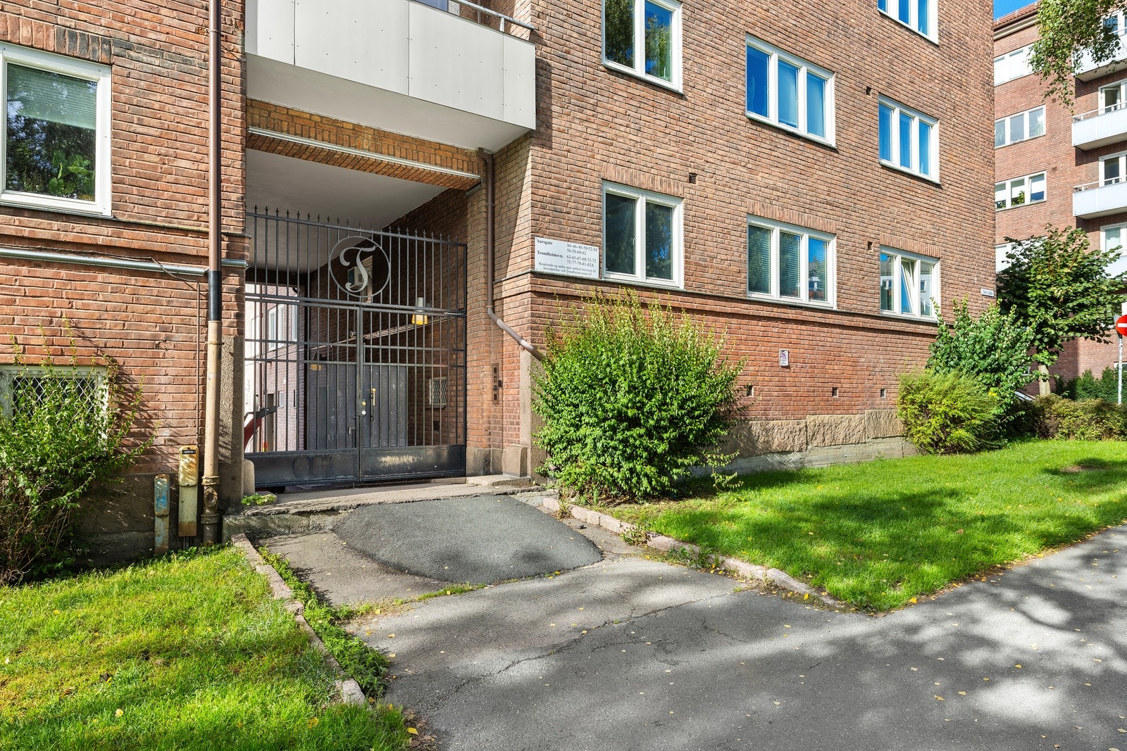 Pent opparbeidet inngangsparti med beplantning og grøntarealer. Galleribilde