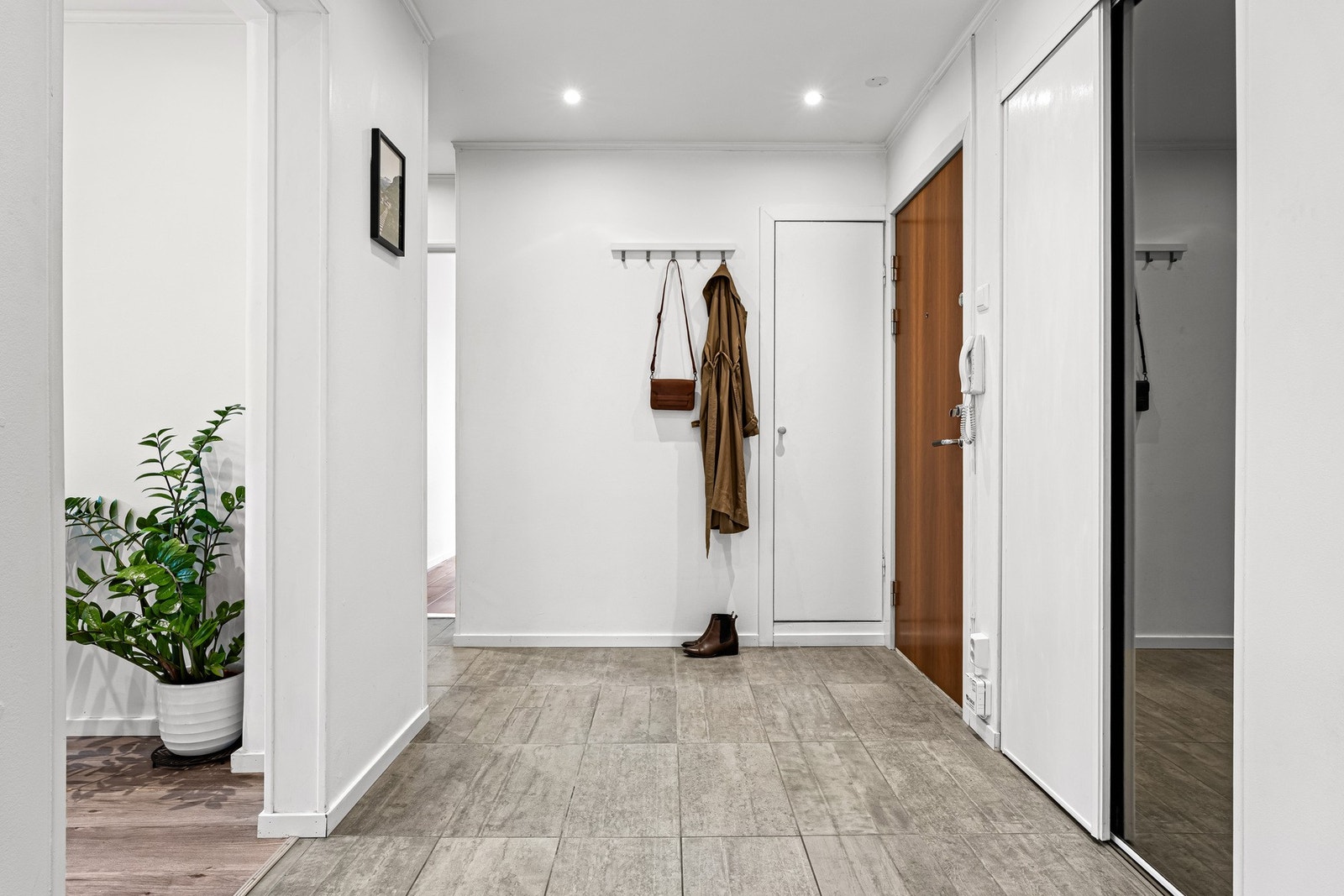 Entreen har lyse vegger, fliser på gulv og tak med nedsenket platehimling og innfelt downlights. Godt med lagringsplass i garderober og en liten bod. Galleribilde