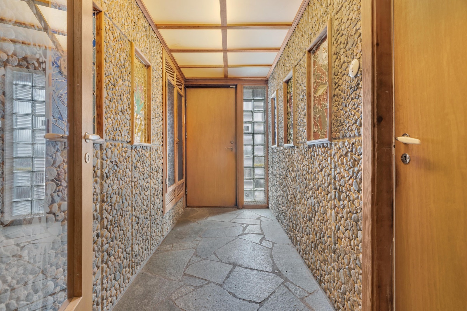 Inngangspartiet er helt unikt med mosaikkrammer på veggene, skifergulv japansk-inspirert lyshimling. Galleribilde